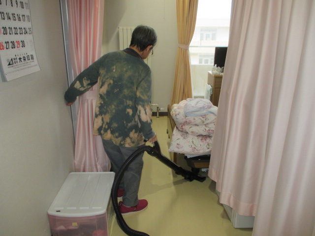 入居者が自室を掃き掃除している様子